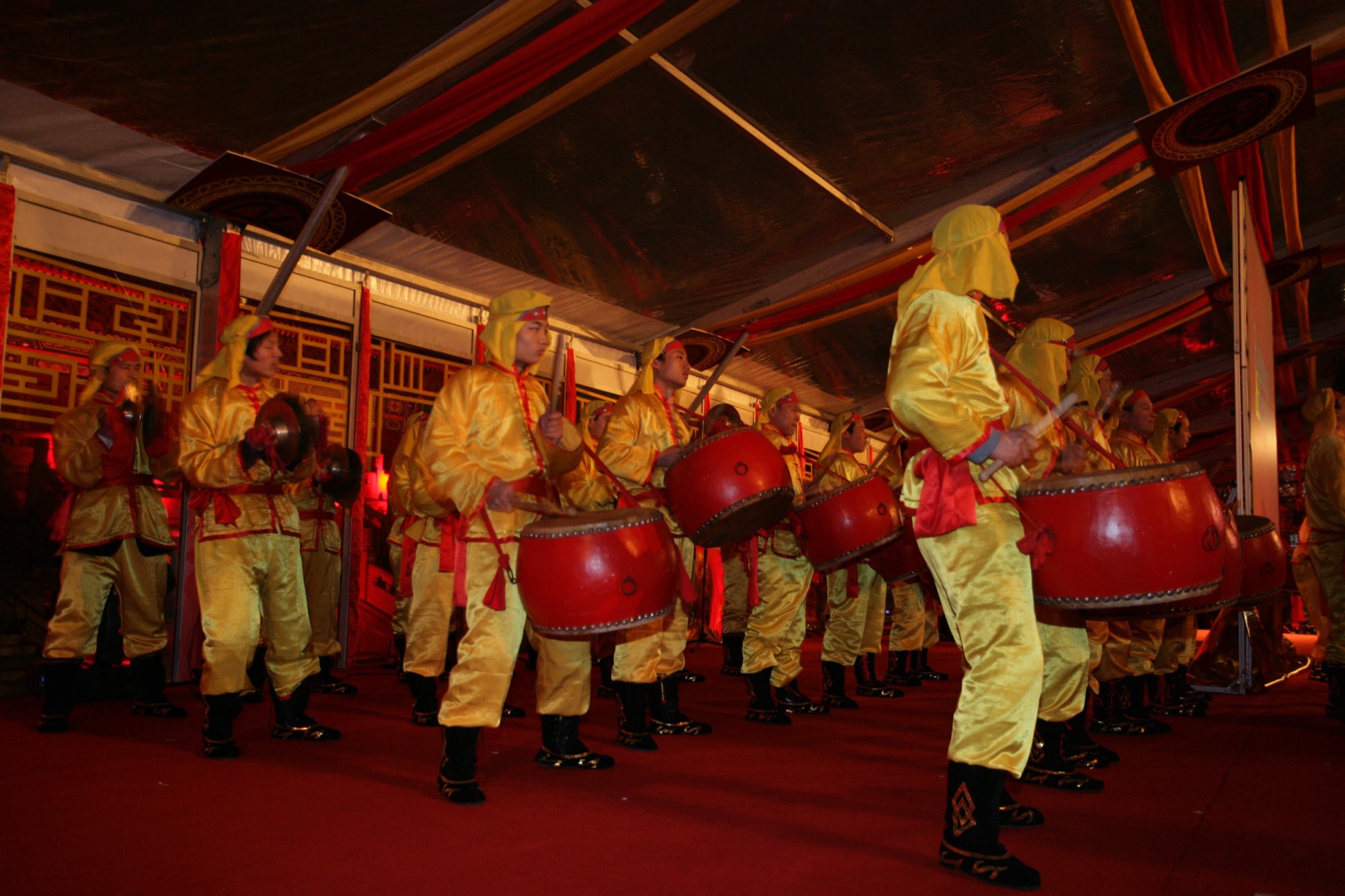 Palace drummers in yellow costumes performing in the tent