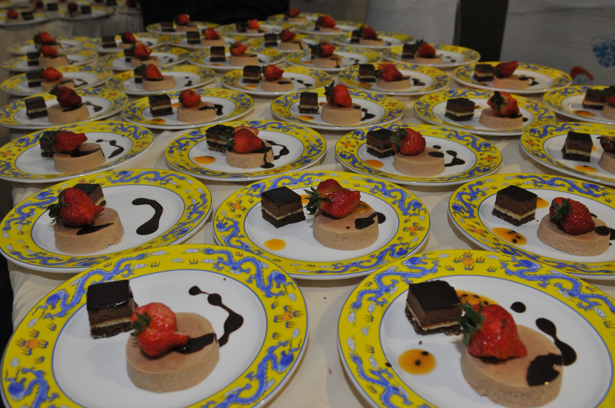 Plated desserts with strawberries on yellow patterned china