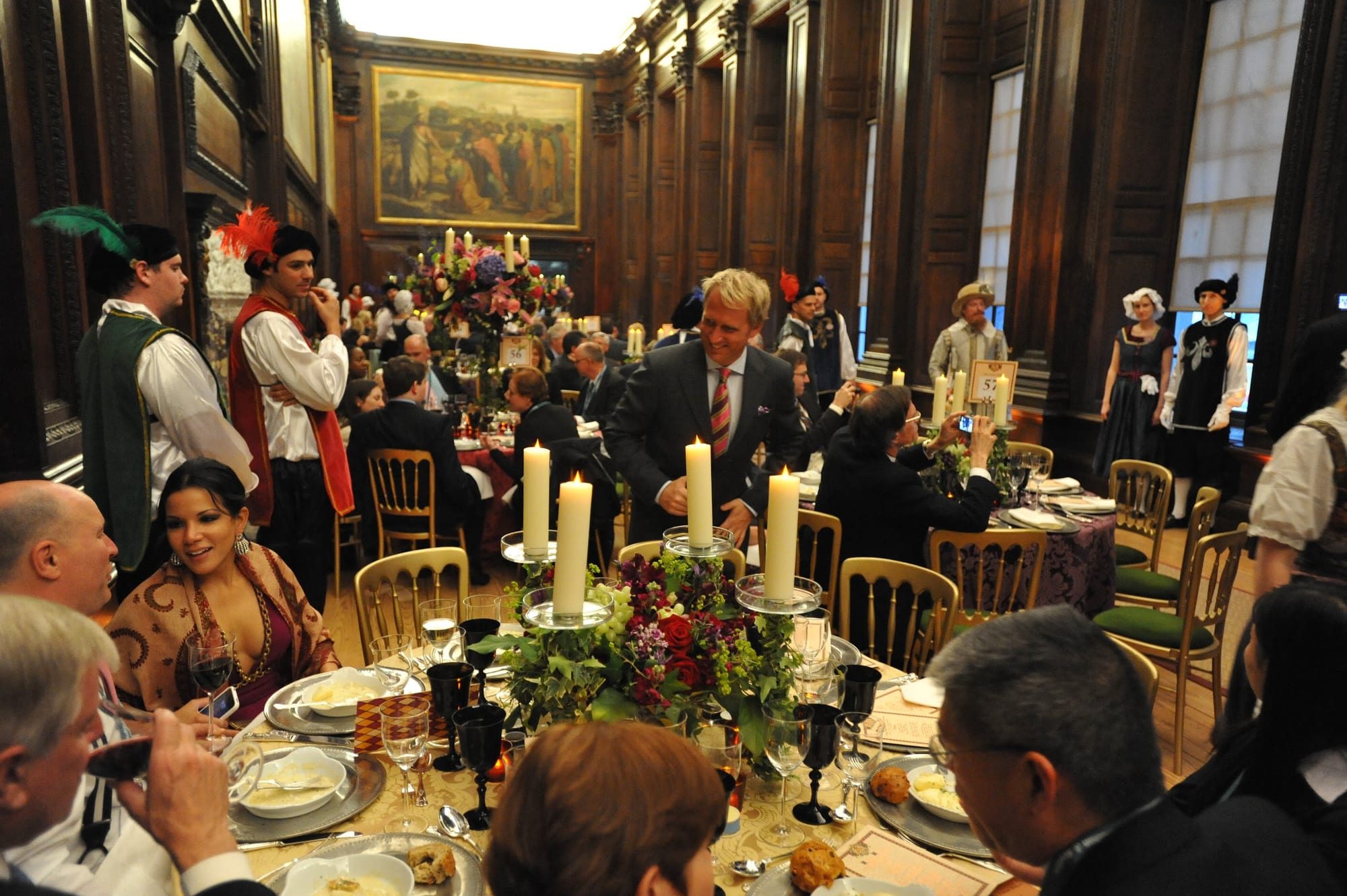 Guests at dinner with costumed performers in a palace hall