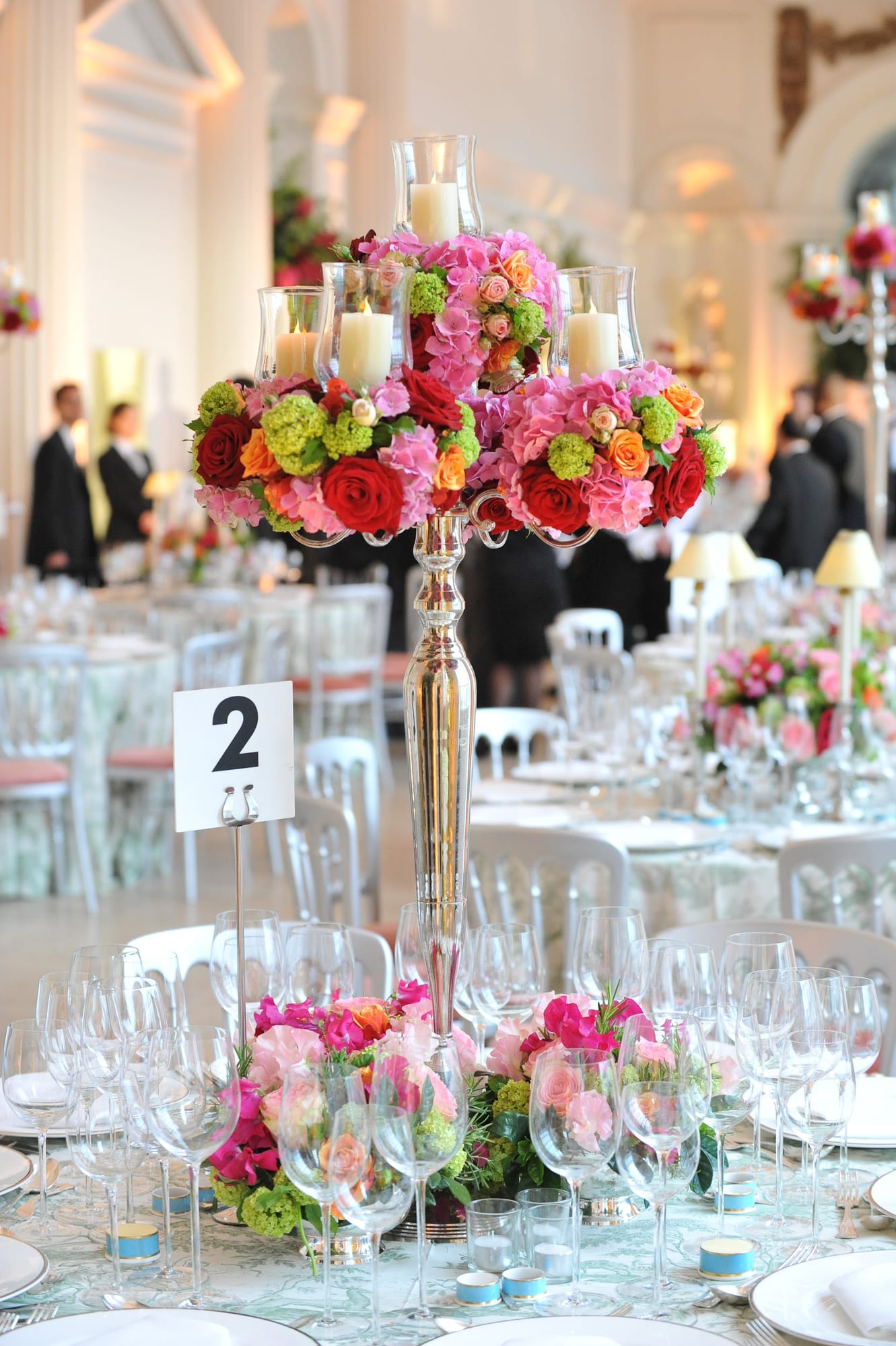 A table set with a tall floral centerpiece