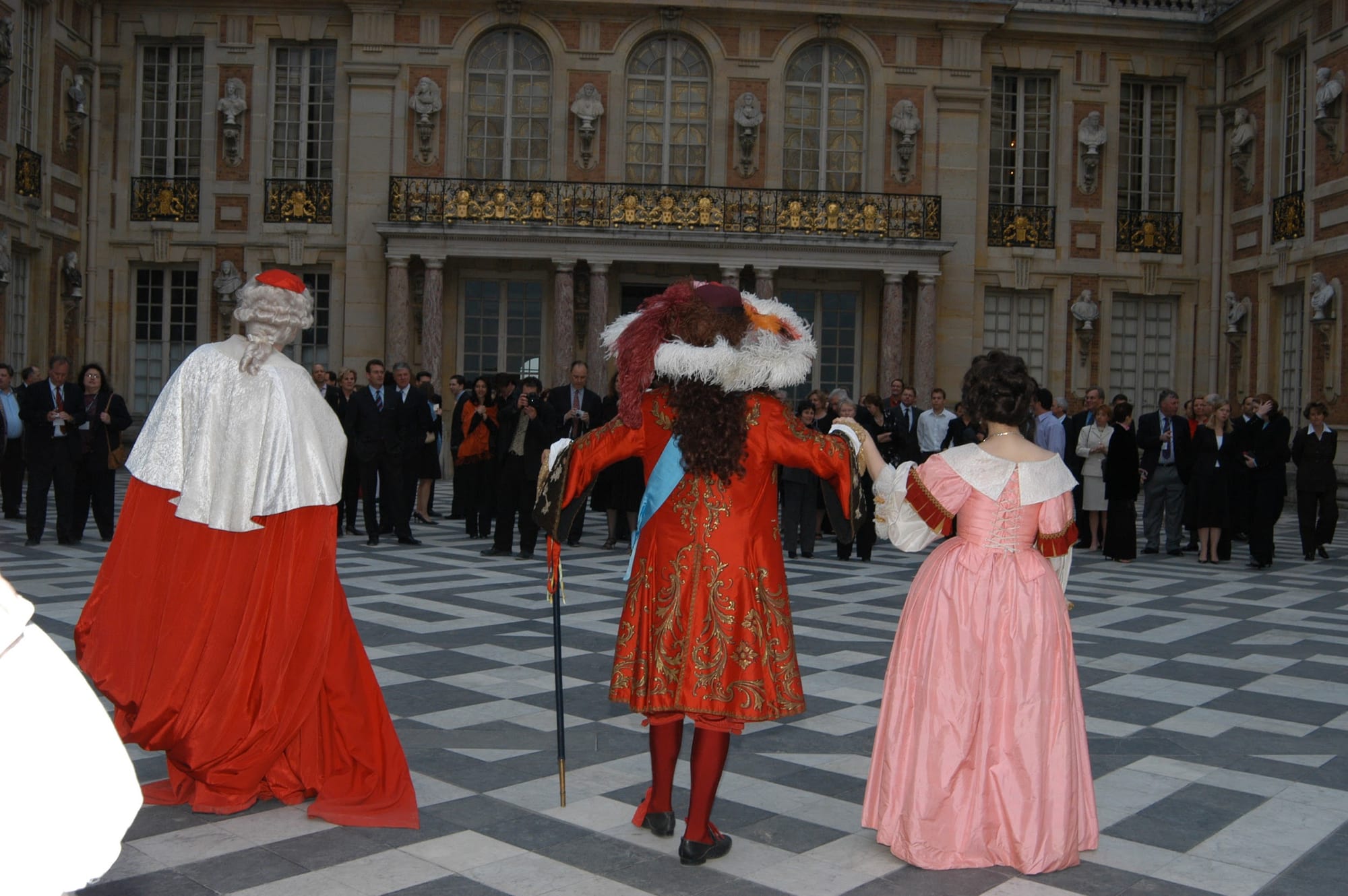 Guests among performers in court costume in the Marble Courtyard