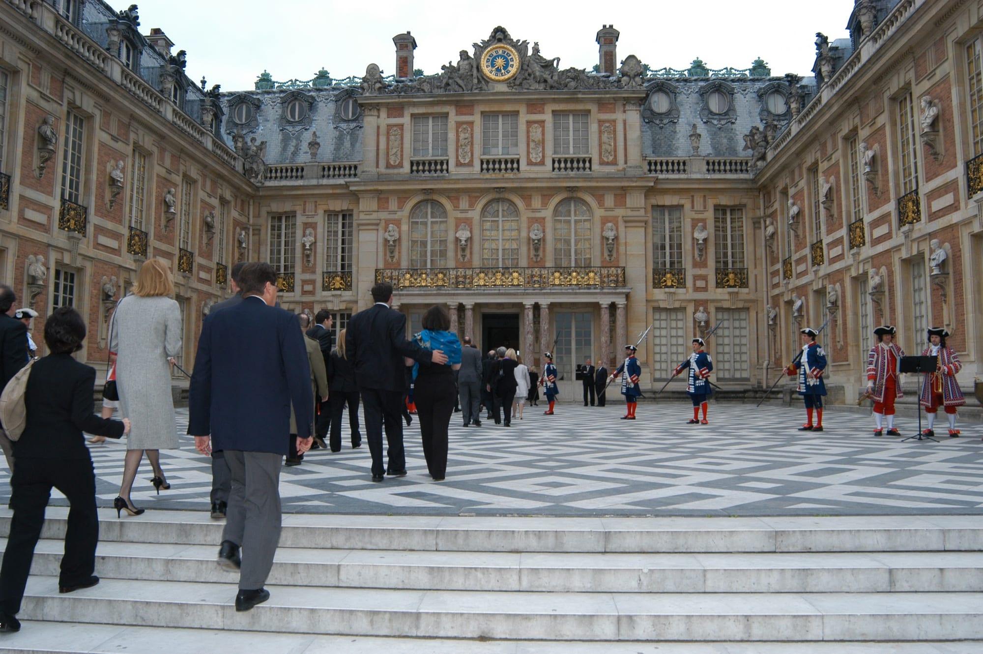 Guests climbing the steps into the Marble Courtyard at Versailles