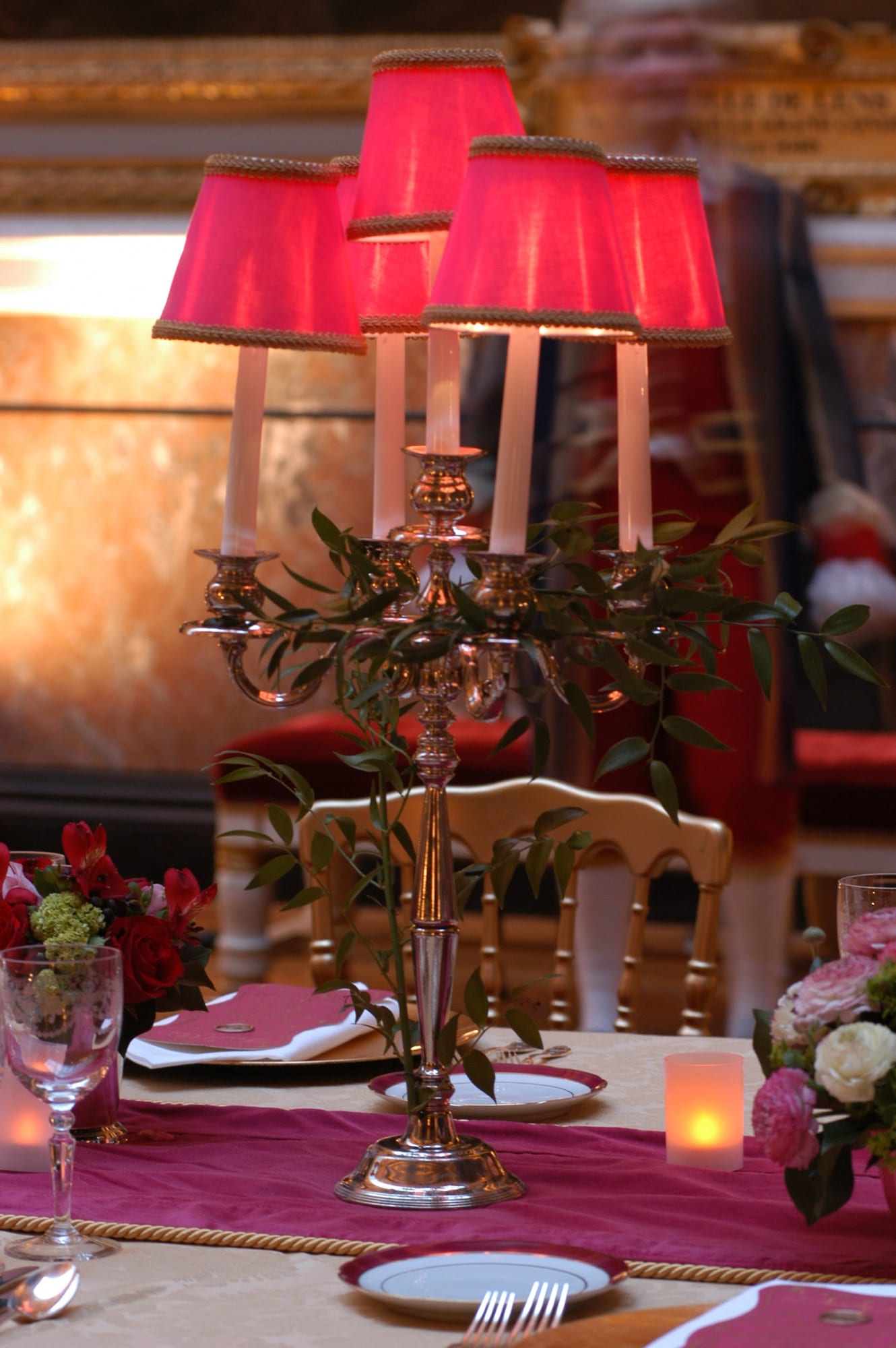 A table set with red lampshades and candlelight